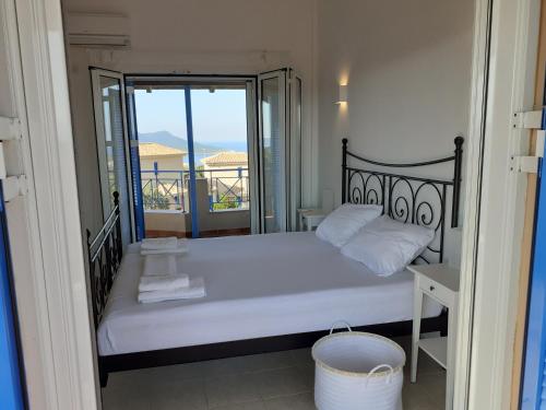 a bedroom with a bed with a view of a balcony at Tapia Hills in Methoni