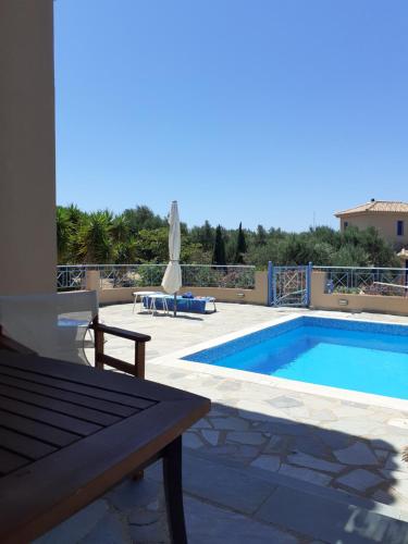 a swimming pool with a table and a bench next to it at Tapia Hills in Methoni
