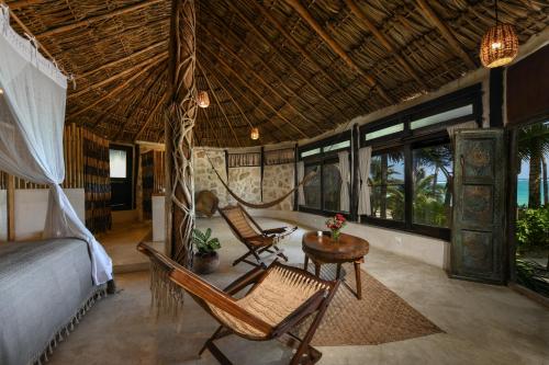 a bedroom with a bed and a table and chairs at Diamante K - Inside Tulum National Park in Tulum