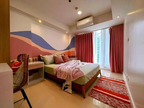 a bedroom with a bed and a desk and a window at Holiday Escape Philippines in Manila