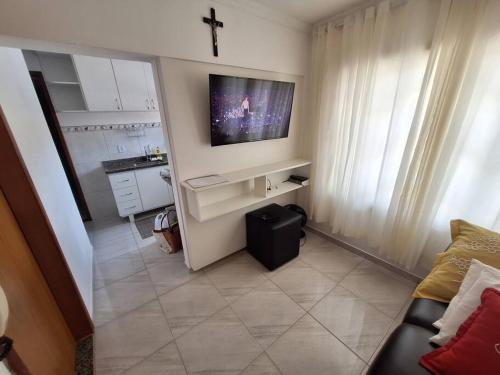 una pequeña sala de estar con TV y sofá en Apartamento Venda Nova do Imigrante en Venda Nova do Imigrante