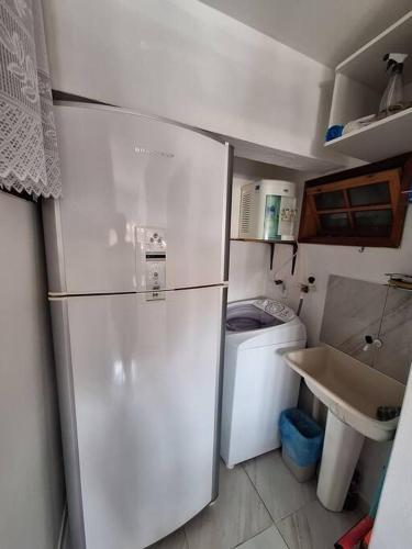 a small kitchen with a refrigerator and a sink at Apartamento "Lavanda" - Venda Nova do Imigrante in Venda Nova do Imigrante