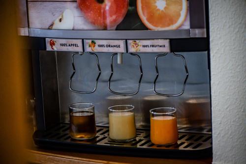 a group of three glasses of juice in a microwave at PANORAMA SportHOTEL in Wenigzell