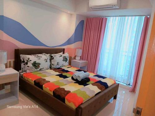 a bedroom with a bed with a colorful blanket at Holiday Escape Philippines in Manila