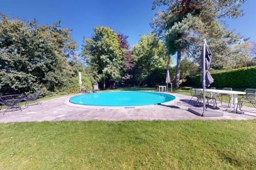 a swimming pool with a table and chairs in a yard at Sy - Les Aywisses in Ferrières