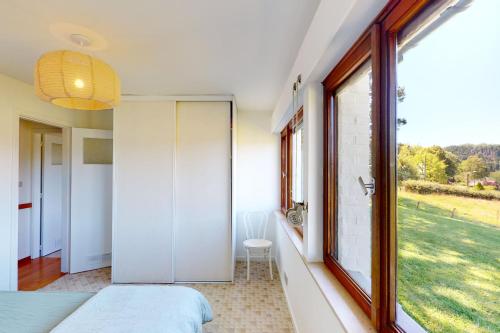 a bedroom with a large window with a view of a field at Sy - Les Aywisses in Ferrières