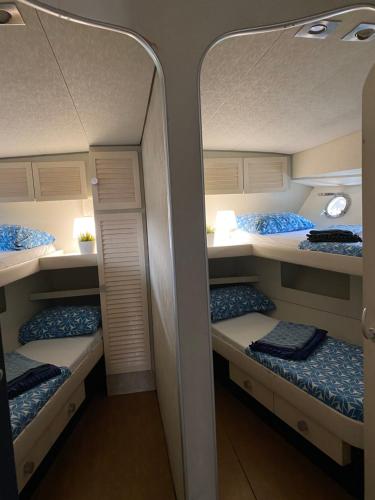two bunk beds in a room with a mirror at Yate Gijon , experiencia unica J in Gijón
