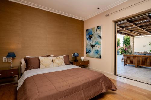 a bedroom with a bed and a sliding glass door at Villa La Curva in Laganas