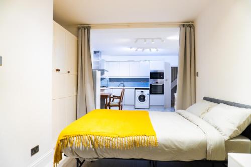 a bedroom with a bed with a yellow blanket at Alpha Grove in London