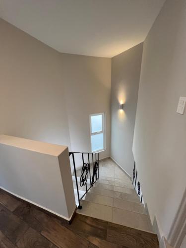 a stairway with a white wall and a window at Privada 400 in Pachuca de Soto