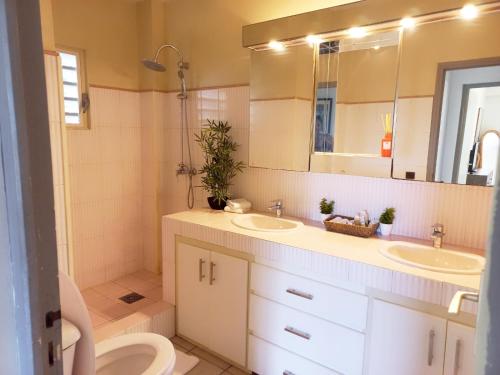 a bathroom with two sinks and a toilet and a mirror at Spacious Villa with Ocean and Mountain view-4 beds in Cul de Sac