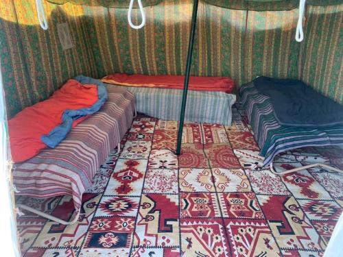 a room with two beds and a rug at Private Camp25km-from DOUZ in Douz