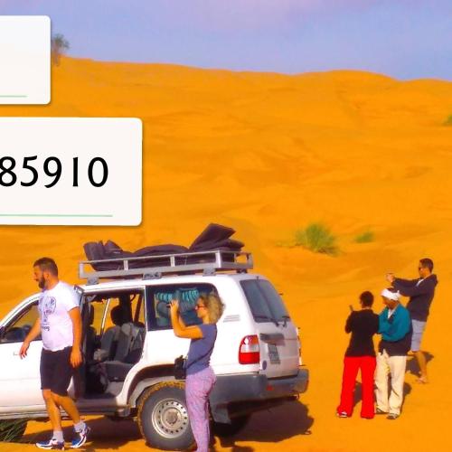 a group of people standing around a van in the desert at Private Camp25km-from DOUZ in Douz