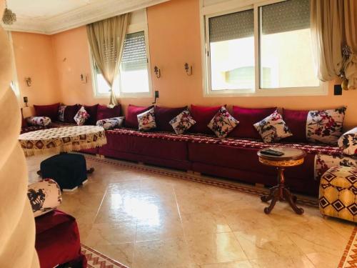 a living room with a red couch and windows at Apartamento hay amal 12 in Salé