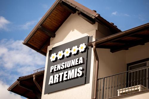 Et logo, certifikat, skilt eller en pris der bliver vist frem på Artemis Villa