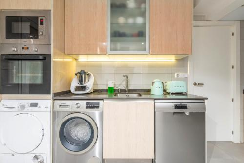 a kitchen with a washing machine and a sink at Bonita habitación con balcón in Villaviciosa de Odón