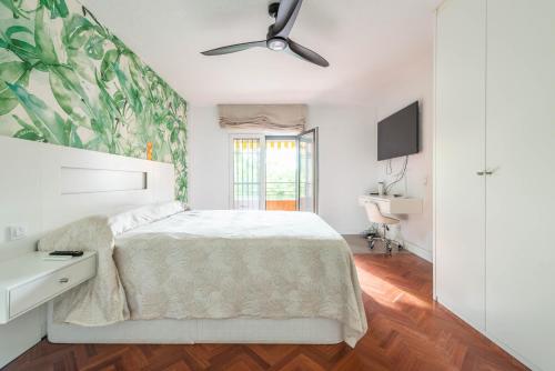 a bedroom with a bed and a ceiling fan at Bonita habitación con balcón in Villaviciosa de Odón