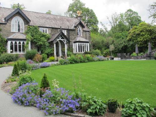 a house with a lawn and flowers in front of it at Cedar Manor in Windermere
