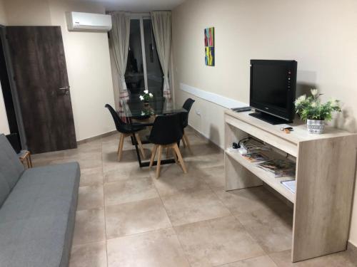 sala de estar con TV y mesa con sillas en Balcarce 526 en Córdoba