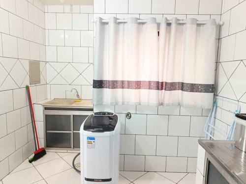 a kitchen with a shower curtain and a trash can at Lindo Apto105 em primavera do Leste in Primavera do Leste