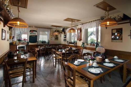 a restaurant with wooden tables and chairs and lights at Pension Luky in Špindlerův Mlýn