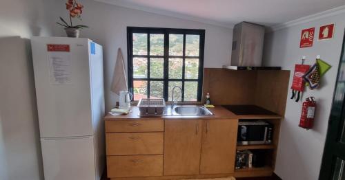 a small kitchen with a sink and a refrigerator at Studio em Machico in Machico