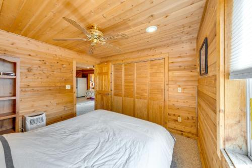 Dormitorio en cabaña de madera con cama y ventilador de techo en Lakefront Wisconsin Escape with Boat Dock and Kayaks!, en Oconomowoc