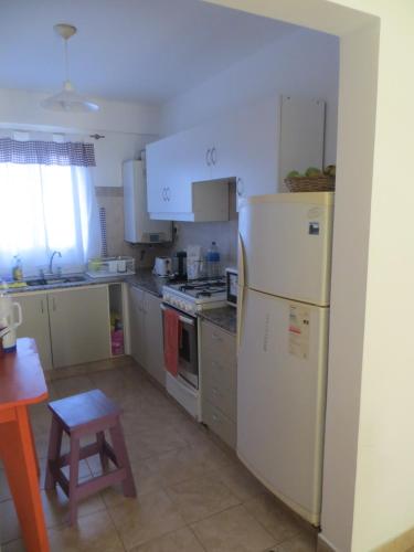 a kitchen with a white refrigerator and a stove at Dpto. 2 dormitorios totalmente equipado in Salta