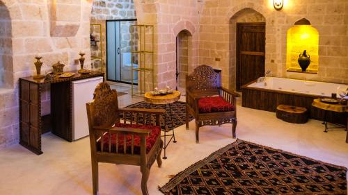 a bathroom with a tub and a table and chairs at AĞA KONAĞI HOTEL in Mardin