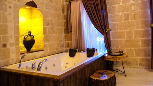 a bath tub in a bathroom with a window at AĞA KONAĞI HOTEL in Mardin