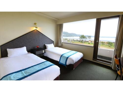 a hotel room with two beds and a large window at Pulse Inn Katsuura - Vacation STAY 44386v in Temma