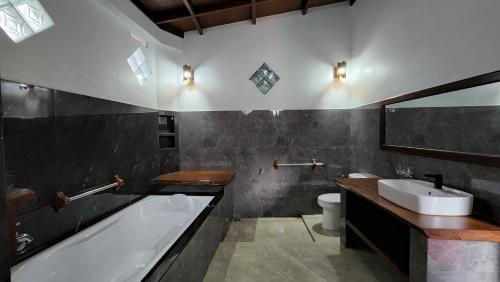 a bathroom with a bath tub and a sink at Sam's Bungalows in Bukit Lawang