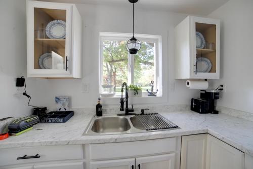uma cozinha branca com um lavatório e uma janela em Stylish Grass Lake Retreat - Steps to Park! em Grass Lake