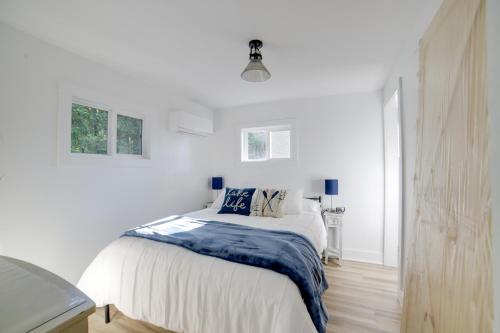 um quarto branco com uma cama e 2 janelas em Stylish Grass Lake Retreat - Steps to Park! em Grass Lake