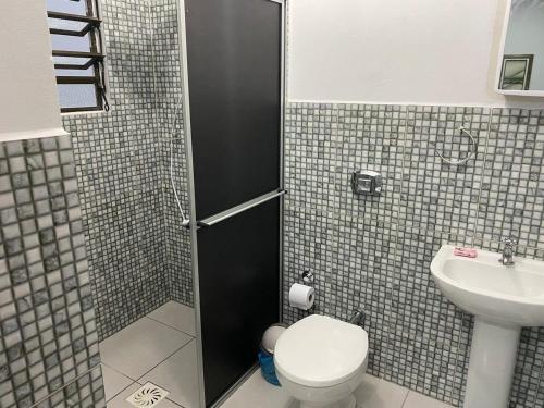 uma casa de banho com um chuveiro, um WC e um lavatório. em RCM Vilas - Casa confortável 1 em Joinville