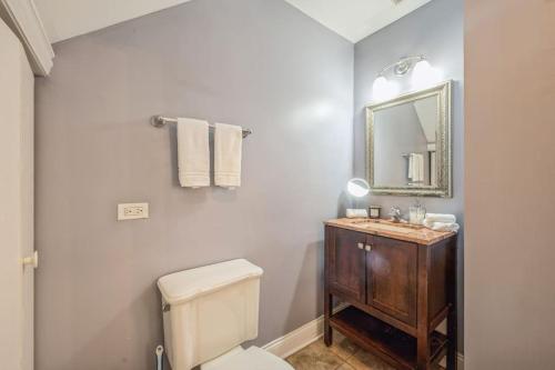 ein Badezimmer mit einem weißen WC und einem Spiegel in der Unterkunft Lovely 2 Bed 3 Miles from DT w Free Parking in Chicago