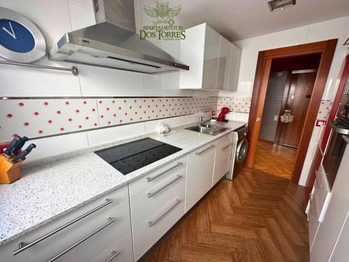 a kitchen with white cabinets and a stove top oven at Dos Torres Ático - Solárium Privado en Calle Alfonso I in Zaragoza