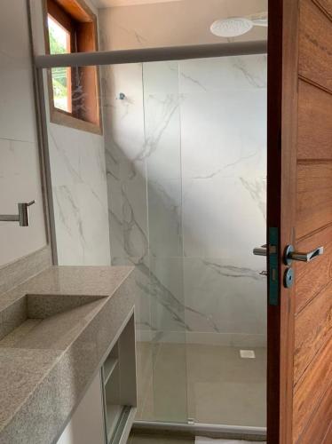 a glass shower door in a bathroom at Apartamento de alto padrão no centro de Barra Grande in Barra Grande