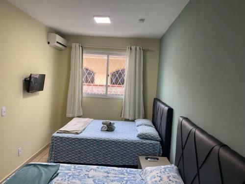 - une chambre avec 2 lits et un ours en peluche sur le lit dans l'établissement RCM Vilas - STUDIO n 03, à Joinville