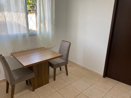 若因維利的住宿－EDIFÍCIO KARINE - STUDIO n 05，一间带木桌和两把椅子的用餐室