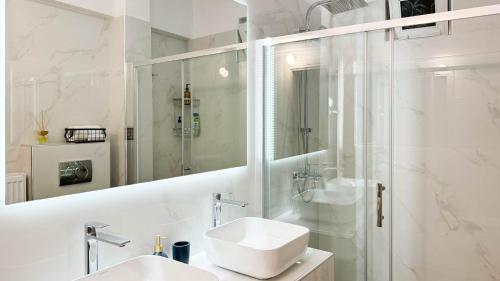 uma casa de banho branca com um lavatório e um chuveiro em V&P House Meteora em Kalabaka