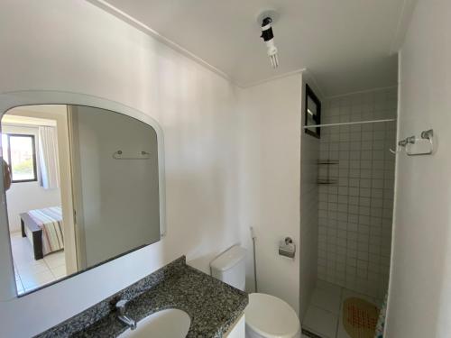 uma casa de banho com um lavatório, um WC e um espelho. em NEO I - Ap. 627 em Maceió
