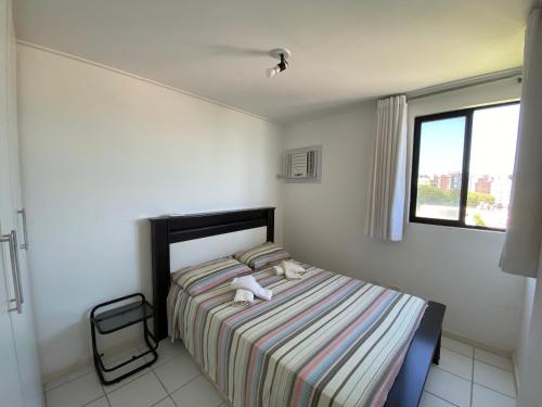 um quarto com uma cama com um bicho de peluche em NEO I - Ap. 627 em Maceió
