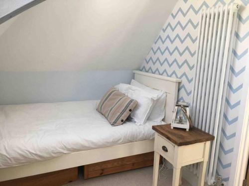 een kleine slaapkamer met een bed en een tafel bij The Old Scout Hut, Sidmouth in Sidmouth