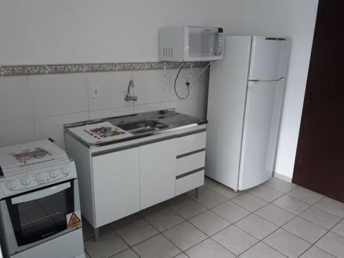 a small kitchen with a stove and a refrigerator at RCM Vilas - STUDIO n18 in Joinville