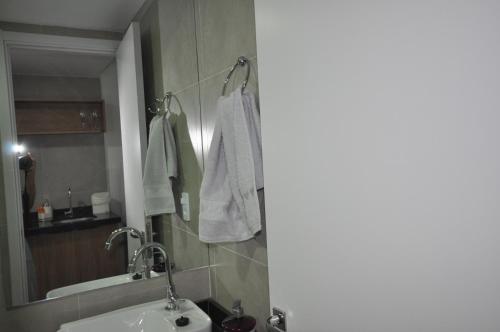 bagno con lavandino e specchio di Studio no centro a Poços de Caldas
