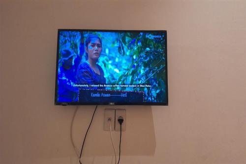 a flat screen tv hanging on a wall at OYO 93101 Al-ainah Family Homestay in Medan