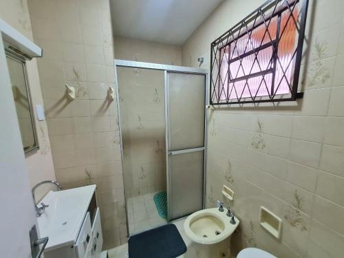 a bathroom with a shower and a toilet and a sink at RCM Vilas - YELLOW HOUSE in Joinville