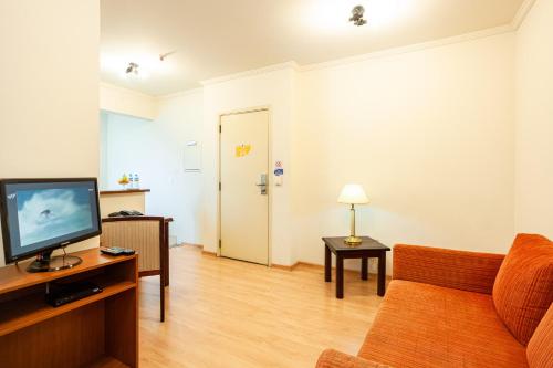 a living room with a couch and a television at Travel Inn Flats Jundiaí in Jundiaí