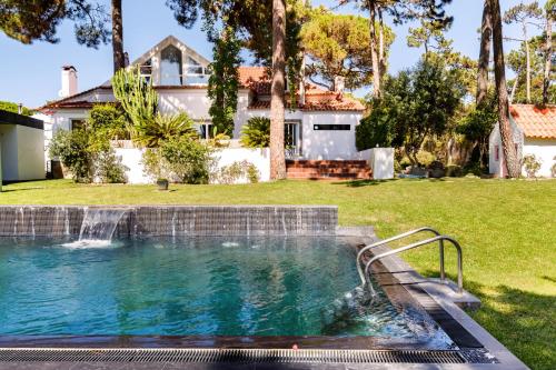 a swimming pool in a yard with a house at Casa Atlântico in Colares